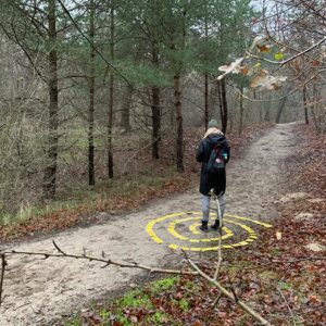 dame in labyrint met kaarten in het bos