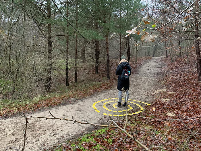 dame in labyrint met kaarten in het bos